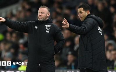 Wayne Rooney and Liam Rosenior on the touchline wearing black Derby County team coats