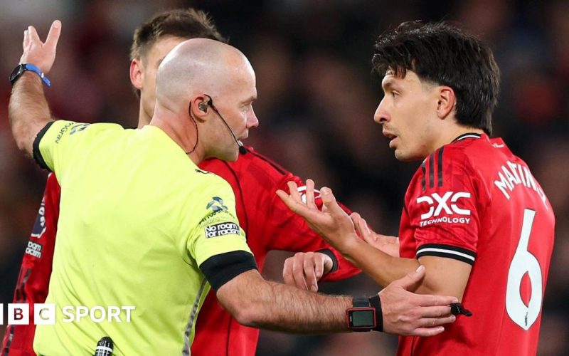 Referee Paul Tierney speaks with Lisandro Martinez of Manchester United after showing him a red card for pulling the hair of Dominic Calvert-Lewin of Leeds United