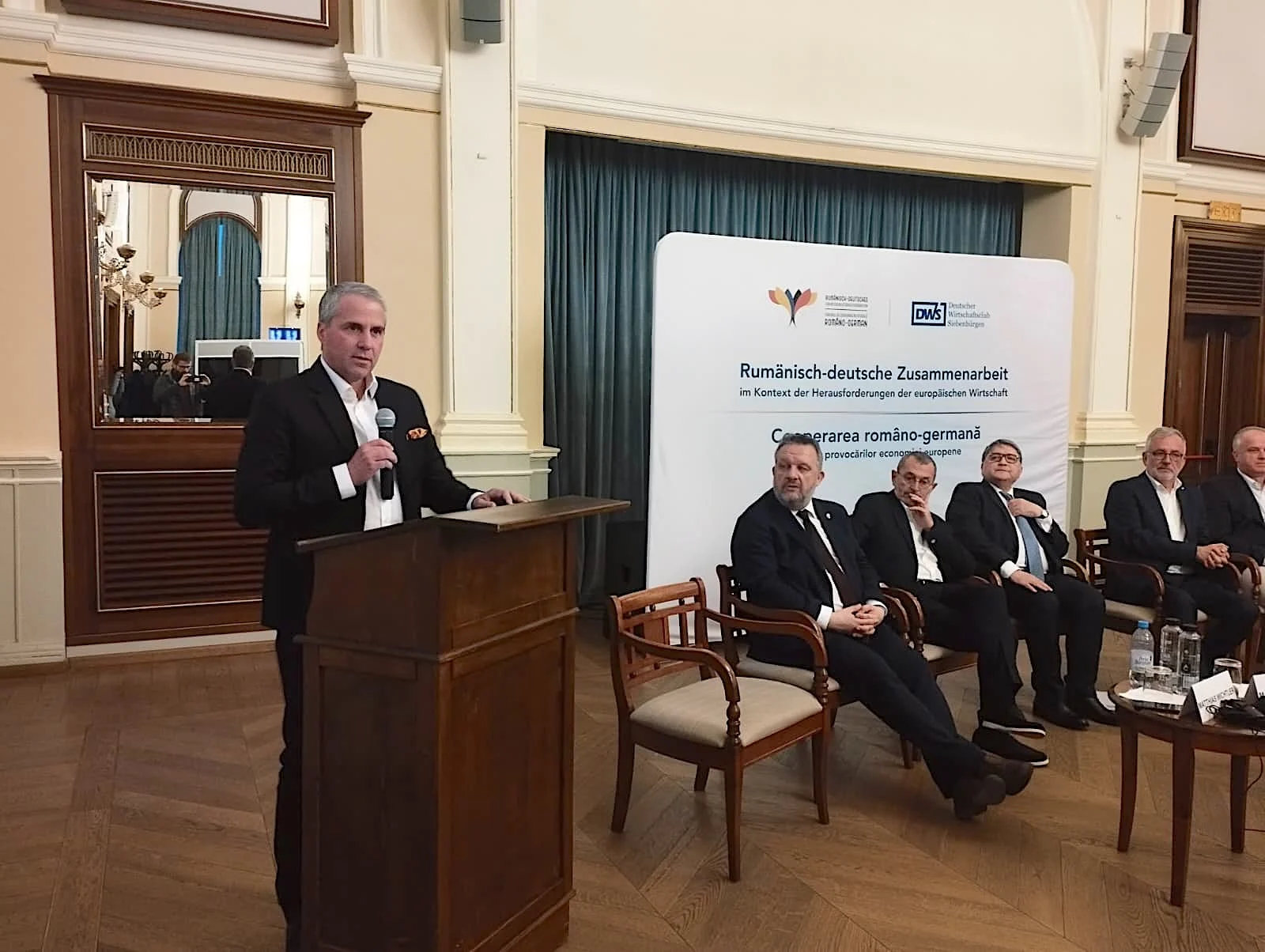 Directorii Aumovio și Bosch critică instabilitatea economică și birocrația la o conferință de business la Sibiu Directorii celor mai importanți investitori germani din Transilvania, Aumovio (fosta Continental) și Bosch, au criticat instabilitatea economică, deciziile politice și reglementările de la nivel european, dar și birocrația care blochează transporturile, în cadrul unei conferințe de business la Sibiu